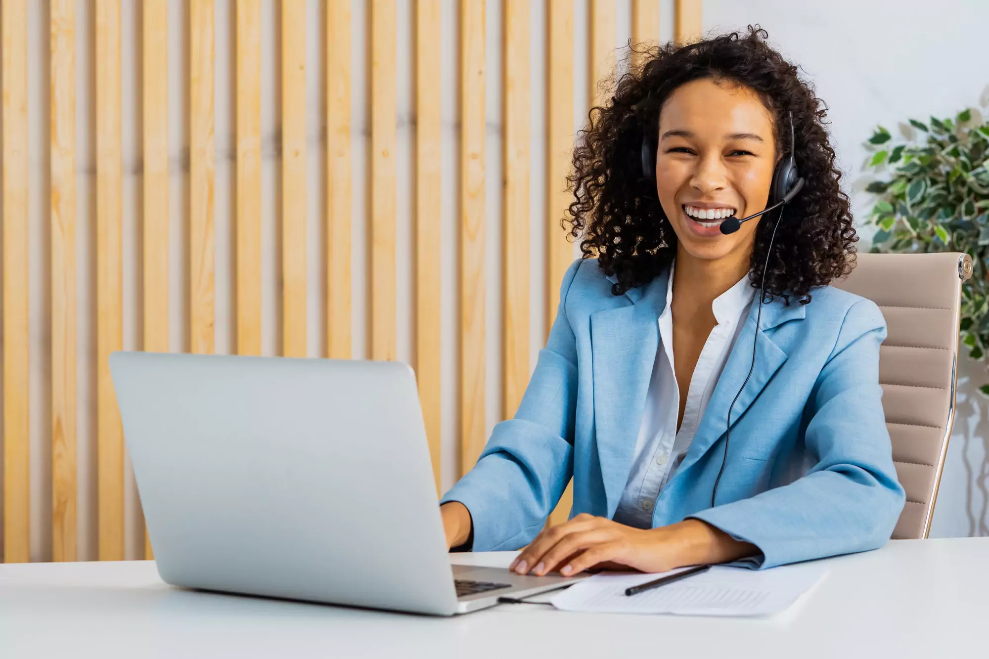 Businesswoman sitting at computer desk in the office with microphone headset