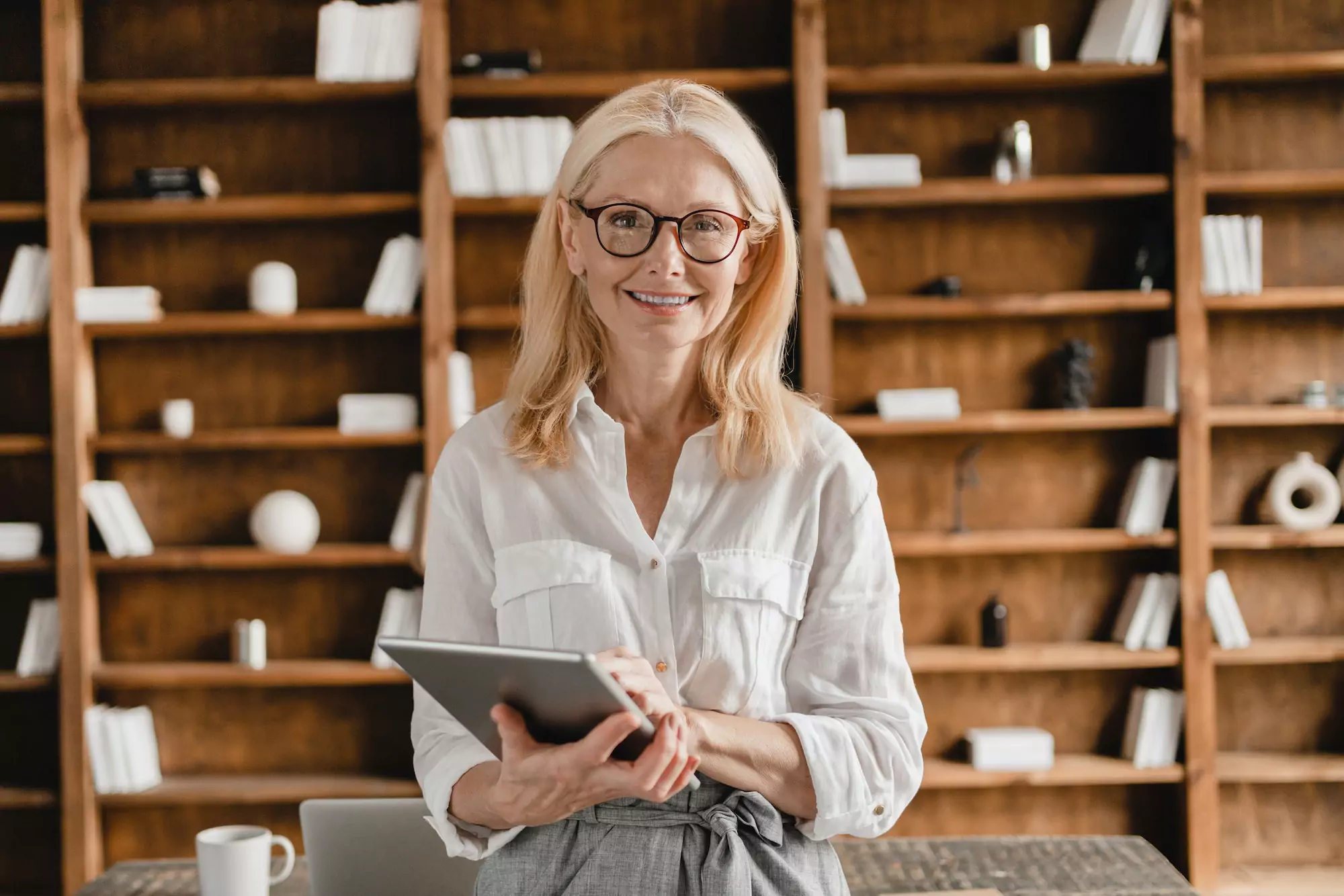 Ceo holding digital tablet looking at the camera while working remotely in home office