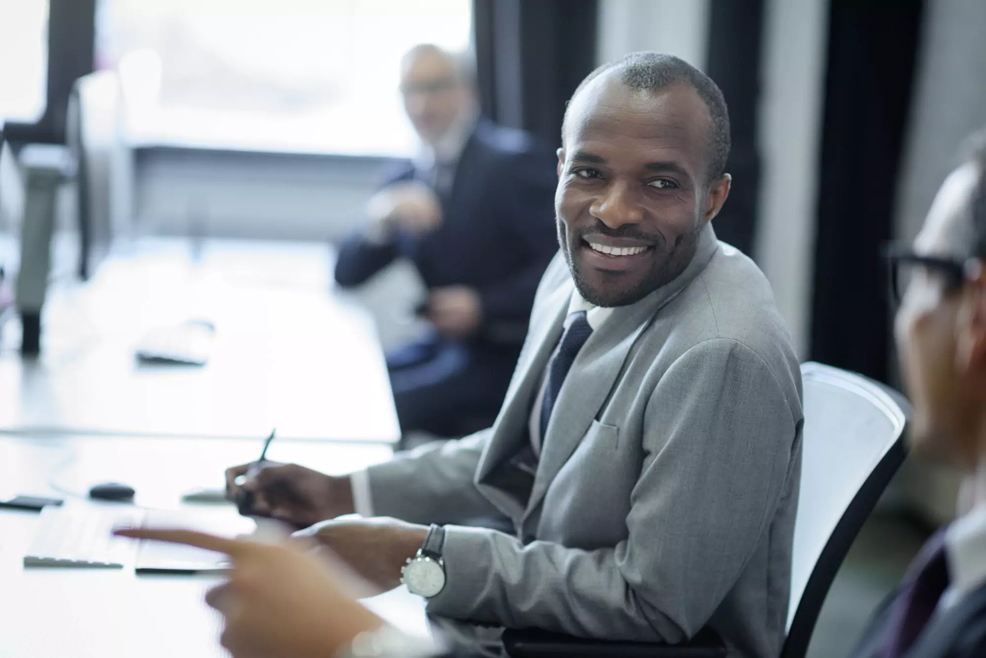 selective focus of multicultural businessmen having conversation at workplace in office