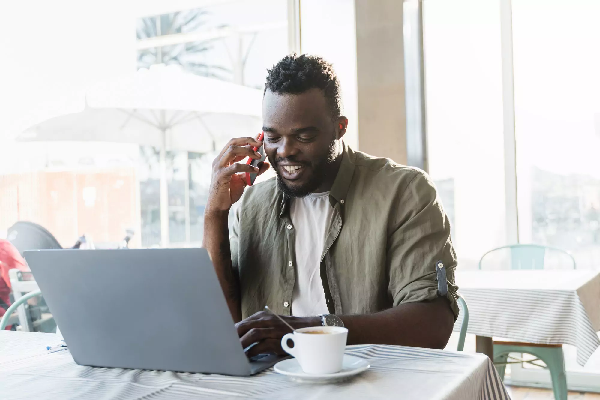 Young african freelancer man working at coffee bar with laptop computer - Focus on face
